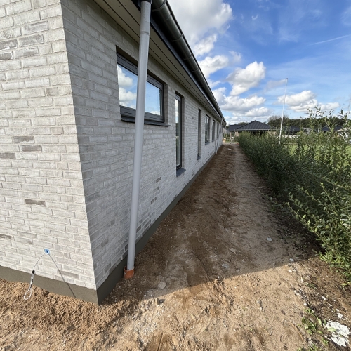 Murer i Kolding har opført moderne nybyggeri med hvid murstensfacade og tagrender.