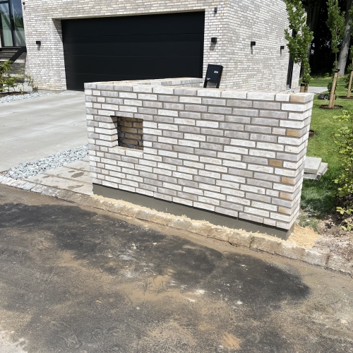 Hvid murstens-tilbygning ved moderne bolig.