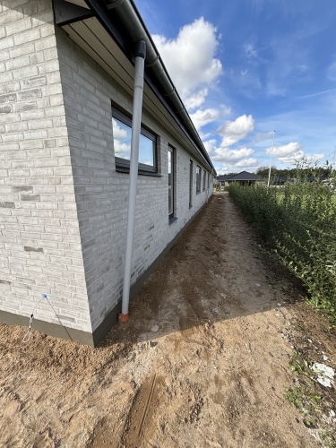 Murer i Kolding har opført moderne nybyggeri med hvid murstensfacade og tagrender.