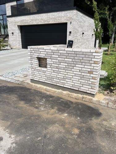 Hvid murstens-tilbygning ved moderne bolig.